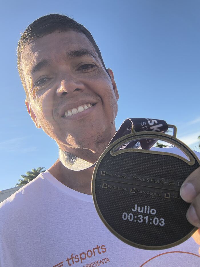 Júlio Prado segurando medalha de corrida com seu nome